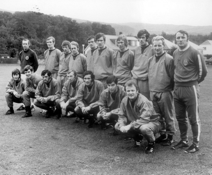 Bobby Clark is in this Scotland squad photo from 1971-72, taken during a training session. Back row, from left — Unknown, Davie Hay, Unknown, Archie Gemmill, John O’Hare, Sandy Jardine, Alex Cropley, Pat Stanton, Jimmy Johnstone, team manager Tommy Docherty. Front row — Unknown, Bobby Clark, Eddie Colquhoun, Bob Wilson, George Graham, Martin Buchan, Billy Bremner.