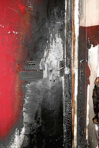 The burnt out front door of the flat