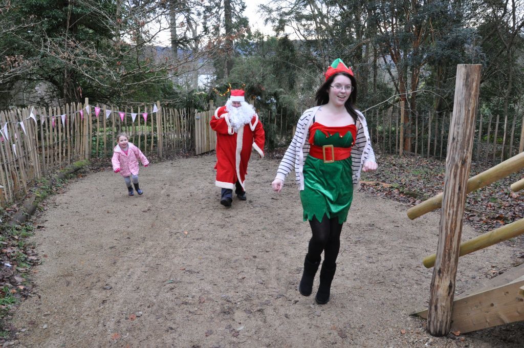 Santa and one of his elves are welcomed by an enthusiastic supporter to the Isle Be Wild play park at Brodick Castle