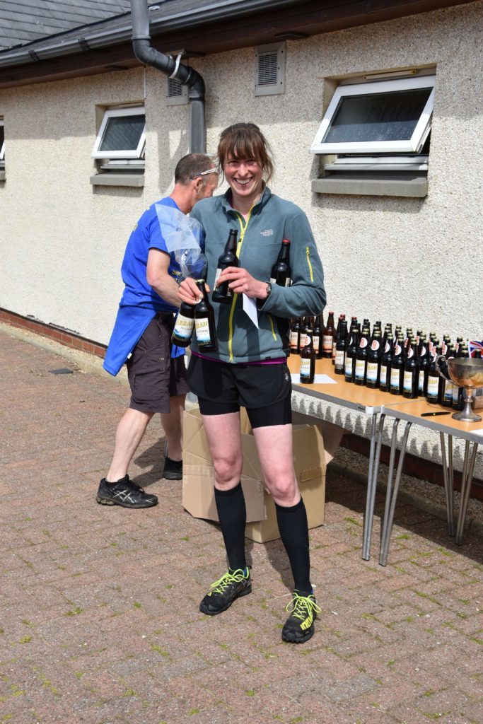 First local female Corinna Goeckeritz receives her medal and the traditional prize of beer.