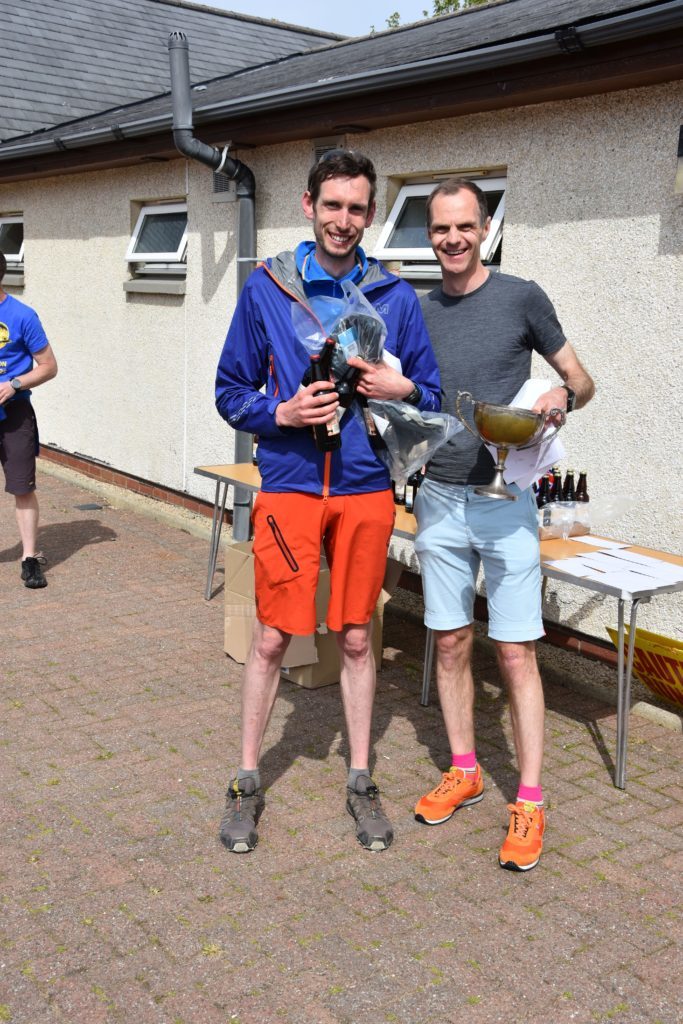 First local male runner, Malcolm Wilkinson receives his medal and traditional beers from race organiser Peter Mackie.