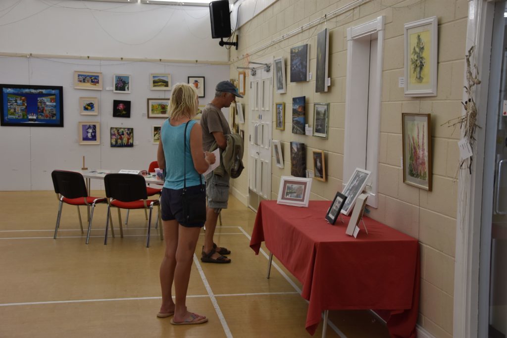 Visitors take in the photographic and floral artworks on display.