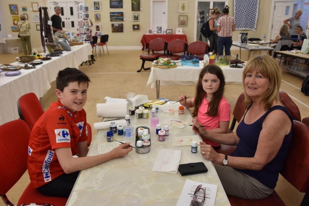 Visiting from Yorkshire, cousins Alex Young and Milly Entwistle enjoy some painting with granny, June Young.