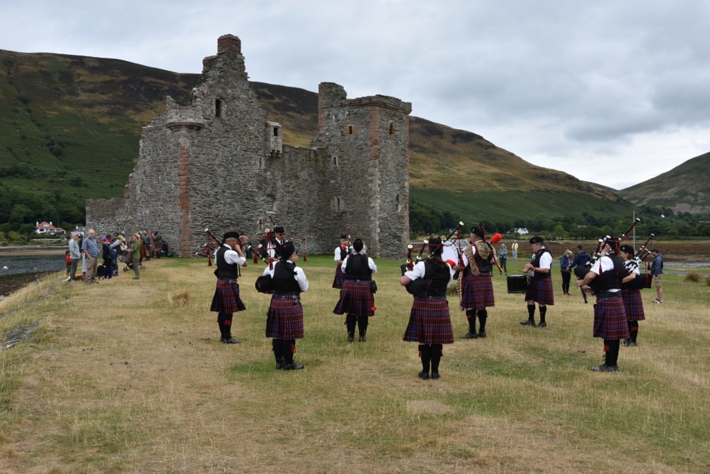 The Arran Pipe Band perform with Lochranza Castle as a dramatic backdrop.