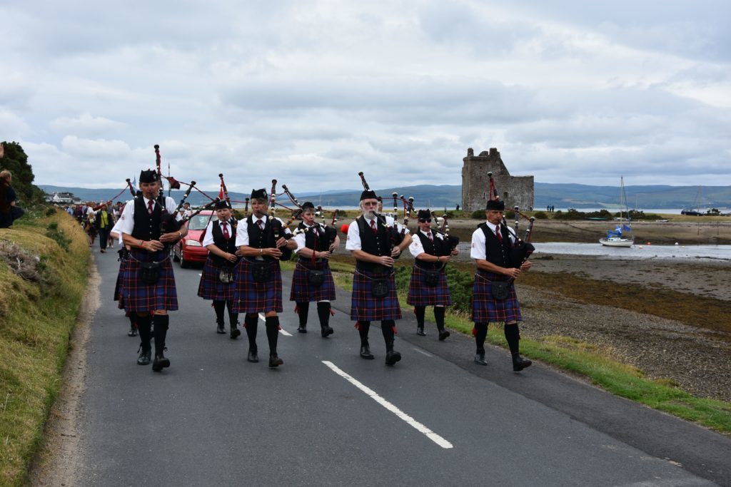 Leading the parade, the Arran Pipe Band with Lochranza Castle behind them.