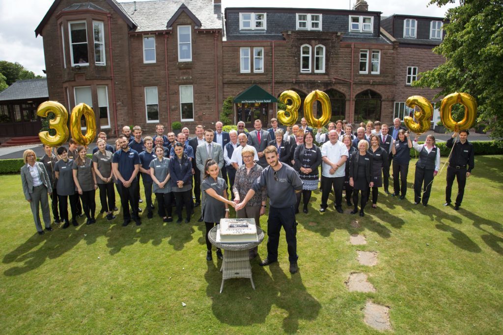 AUGUST - Auchrannie Resort team members join managing director Linda Johnston in cutting a large cake during their 30th birthday celebrations.