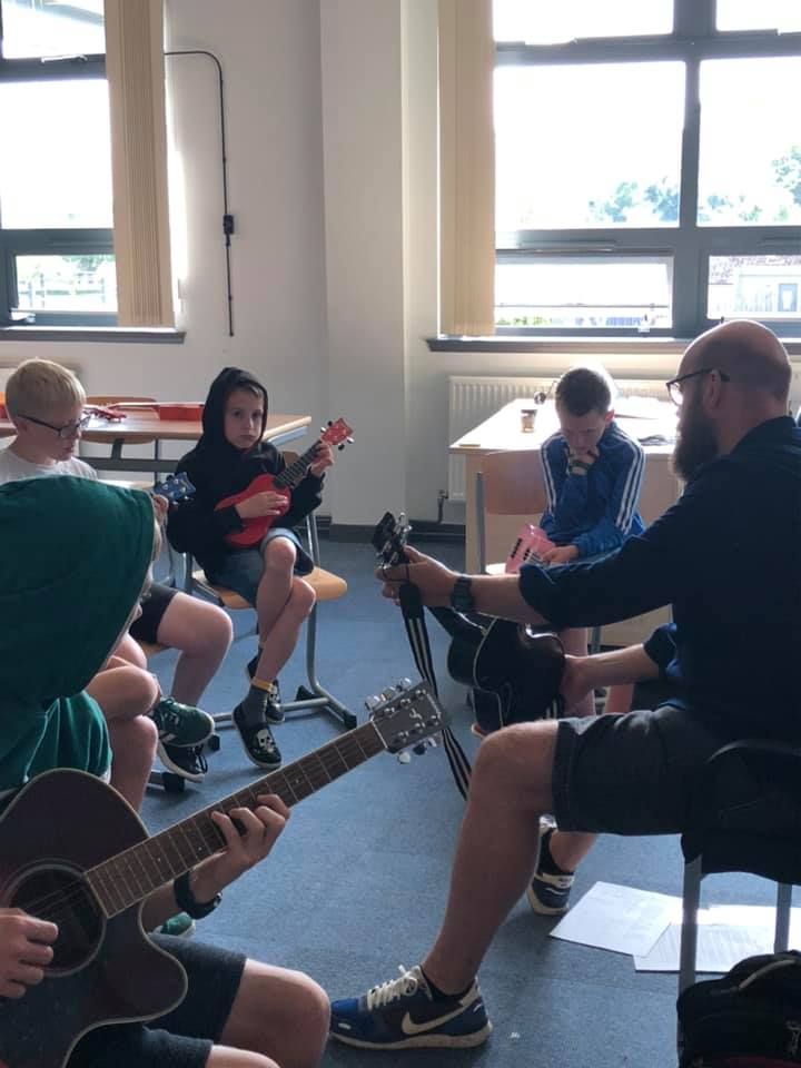 Findlay Napier teaches pupils how to play the ukulele.