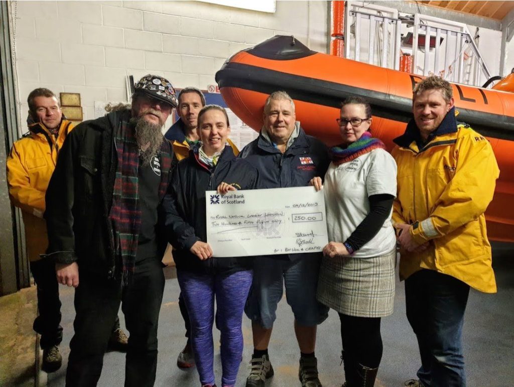 Kat and Steve Sparshott present a cheque to representatives of the Arran RNLI.