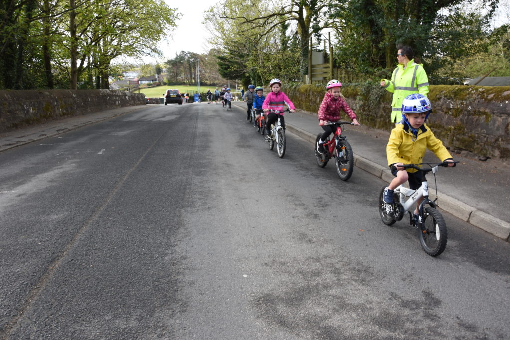 A teacher keeps close eye on the younger pupils on their bikes. 0