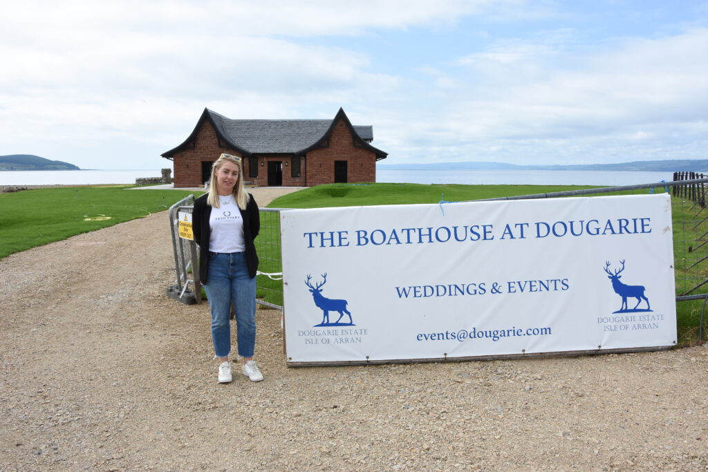 Malin at the sign for The Boathouse at Dougarie.