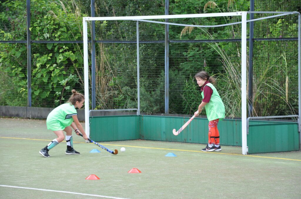 Two young girls practice their goal scoring and defending skills.