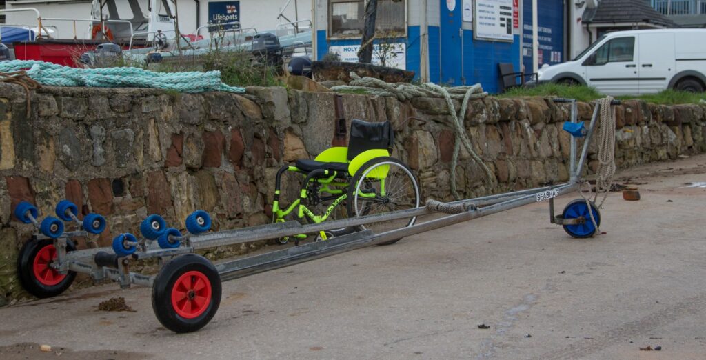 Gone rowing. A wheelchair and trailer are left on the Lamlash slipway.