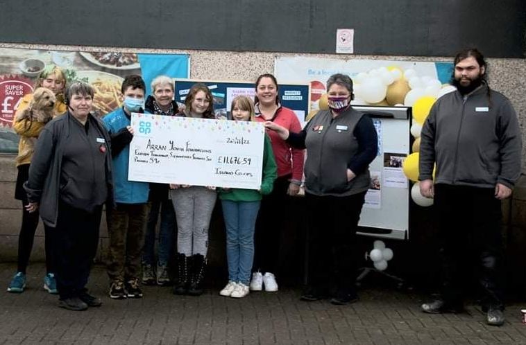 Members of the Arran Youth Foundations receive their cheque from Brodick Co-op manager Liz Mclean and team manager Carol Harwood.