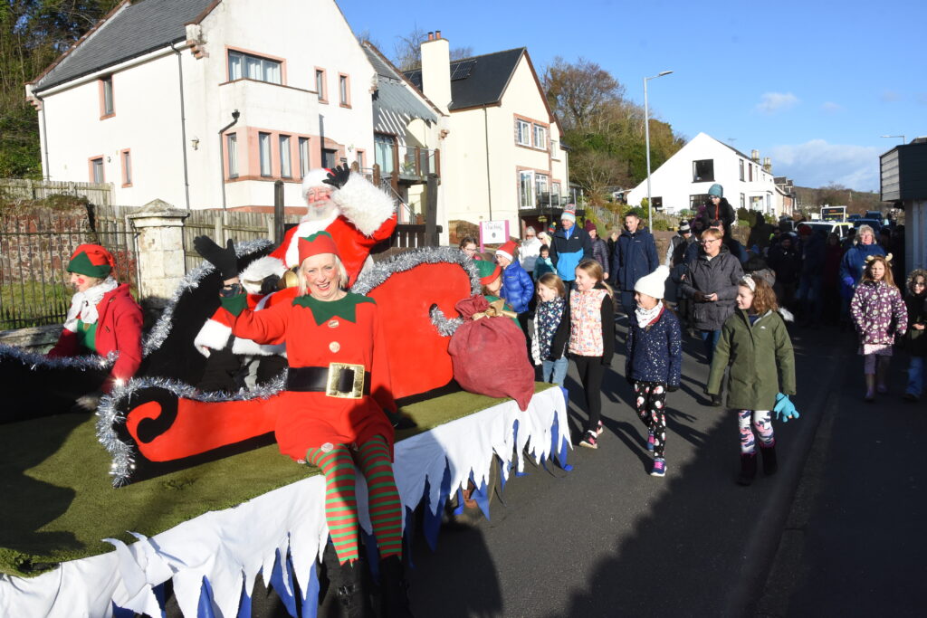 Santa and his elves wave to the crowds from his sleigh.