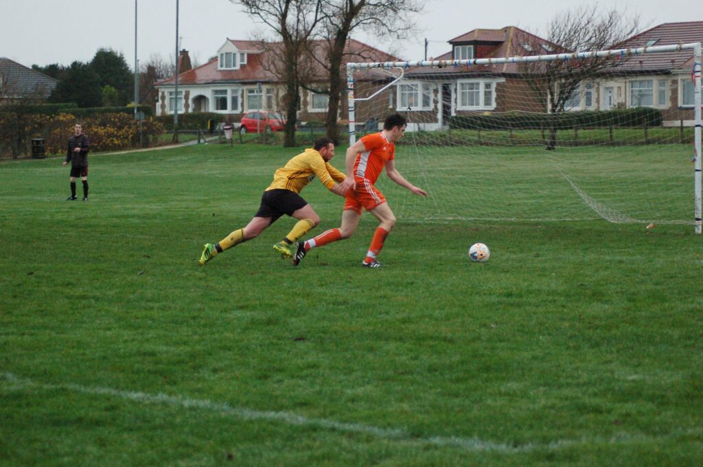 Joel Small prepares to score for Arran as the Girdle Toll keeper scrambles to stop him.