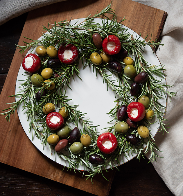 Serving wreath made of rosemary, olives and stuffed peppers