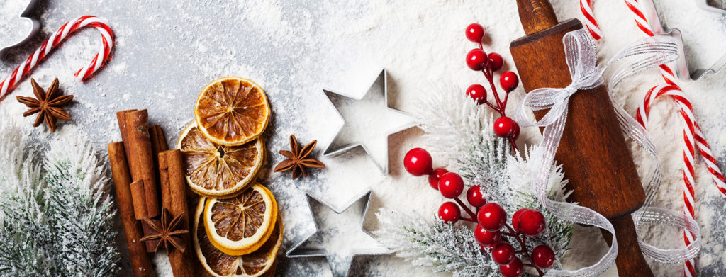 Bakery food background for cooking christmas baking with rolling pin, scattered flour and spices decorated with fir tree top view.