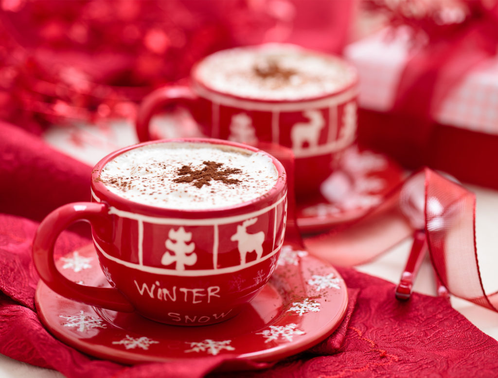 Red and white Christmas cups and saucers filled with gingerbread latte