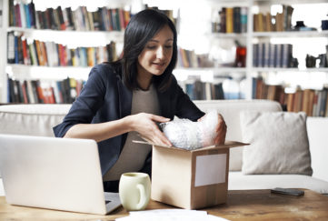 Woman preparing parcel for shipment in her cozy loft apartment