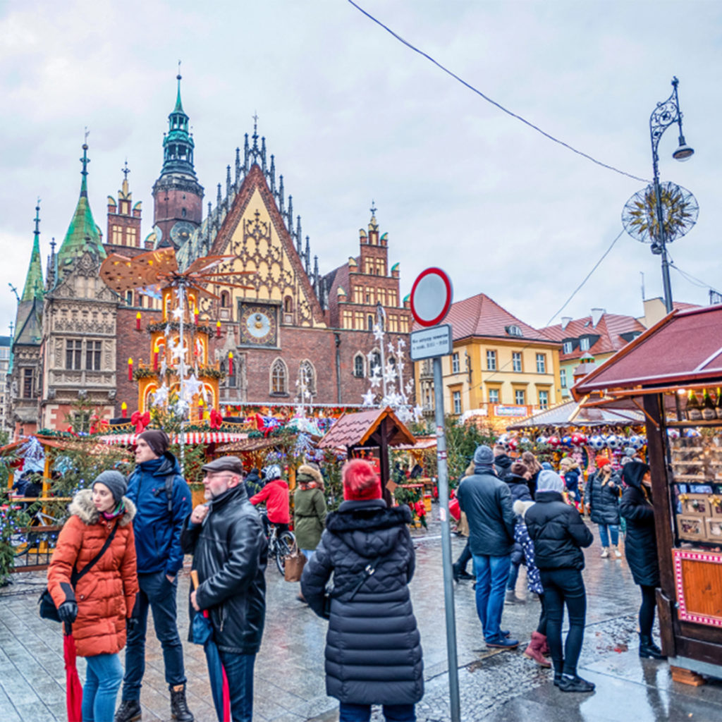 Ornate architecture, spires and gables, with stalls, lights and visitors