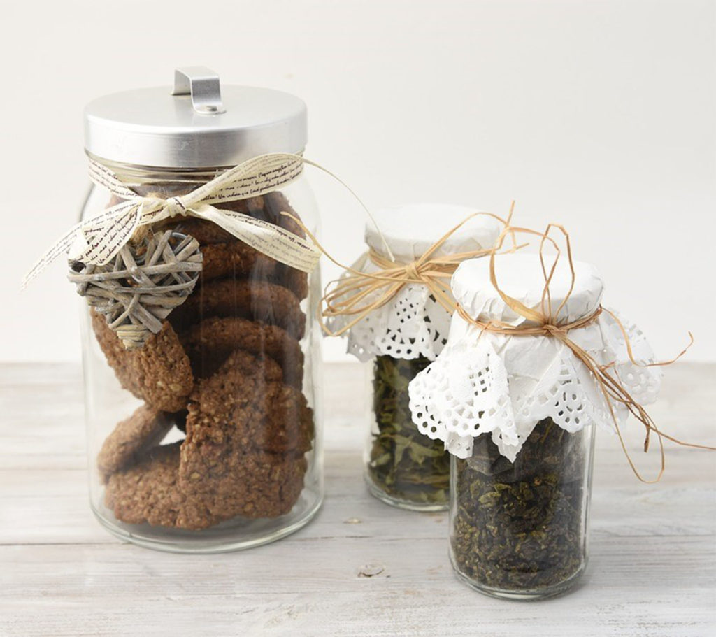 One jar of biscuits and two of jam/chutney, with paper doilies tied with string on top of the lid