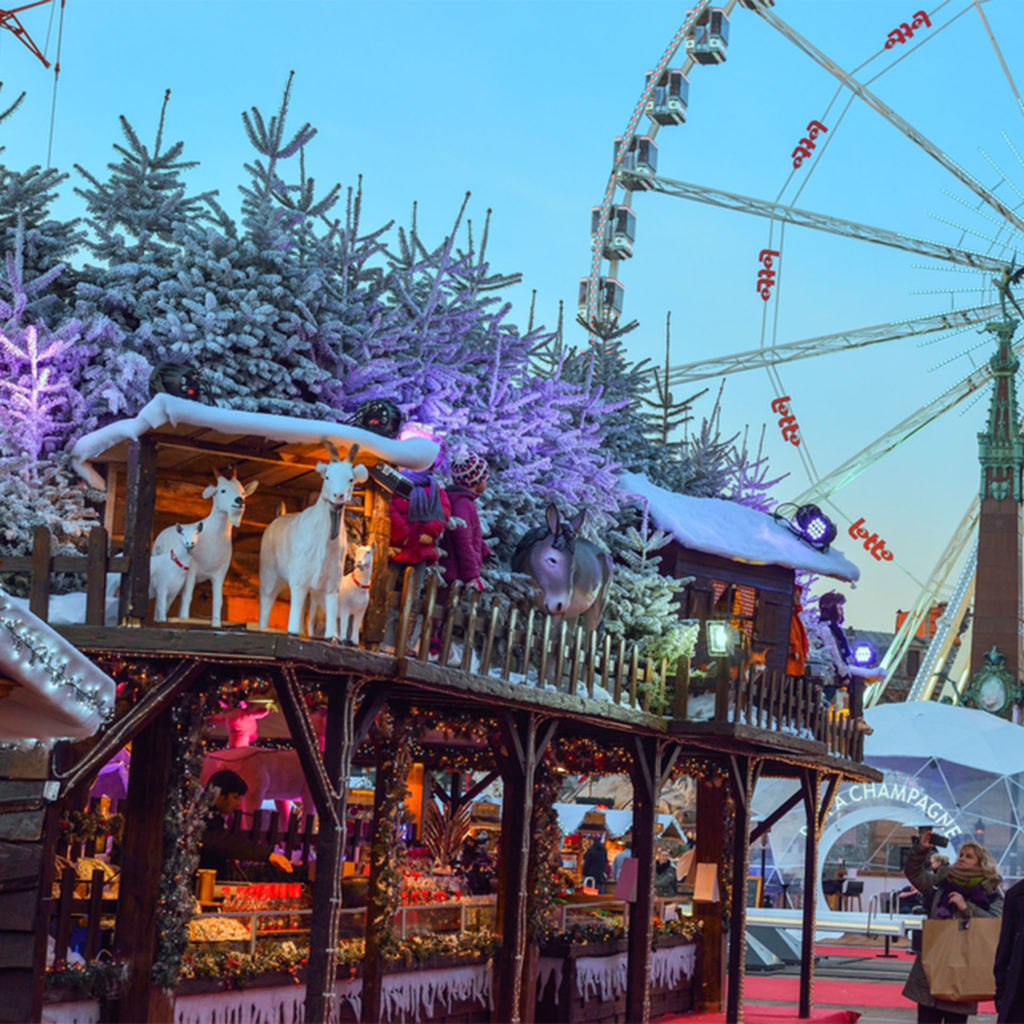 Life size goats, donkey, snowy trees and children... all on the roof of a confectionery stall. Ferris wheel in background.