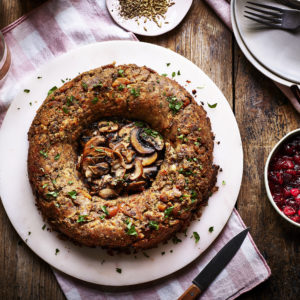 Ring shaped sausage stuffing scattered with herbs, centre filled with sliced mushrooms