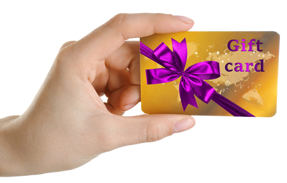 Woman's hand holding gift card decorated with purple ribbon