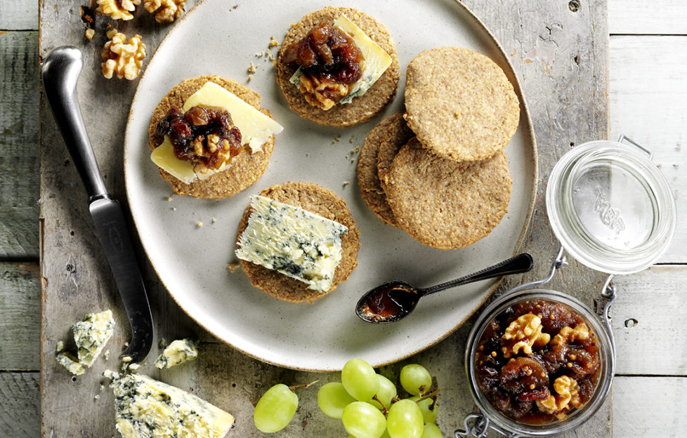 Plate of oatcakes with cheese, grapes and jar of home made chutney