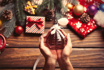 Perfume in hand with Christmas background Pic: Shutterstock