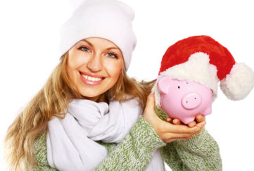 Lady holding piggy bank wearing santa hat Pic: Shutterstock