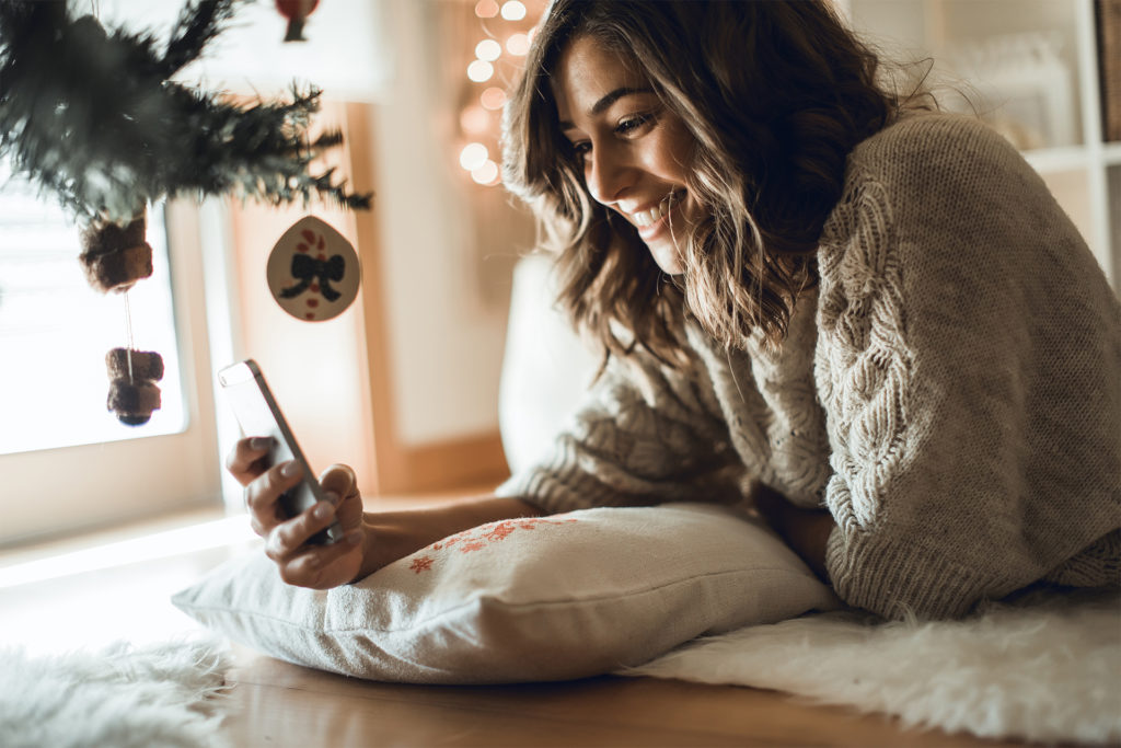 Woman lying by Christmas tree, same as featured image