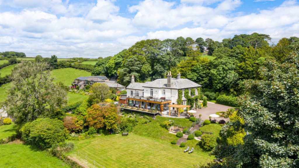 Large house set in lush countryside, looking down from high angle