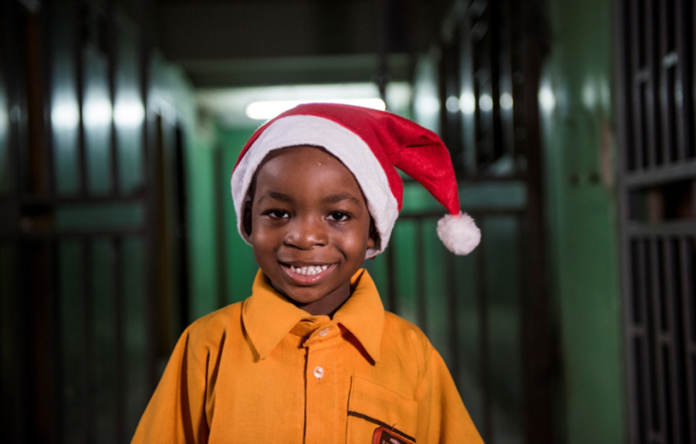 A young boy in a Santa hat