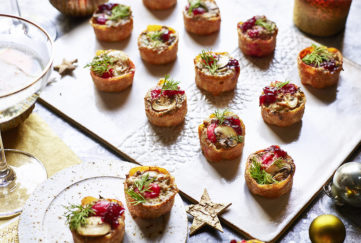 Christmas canapes on a board with dill sprigs and mushrooms