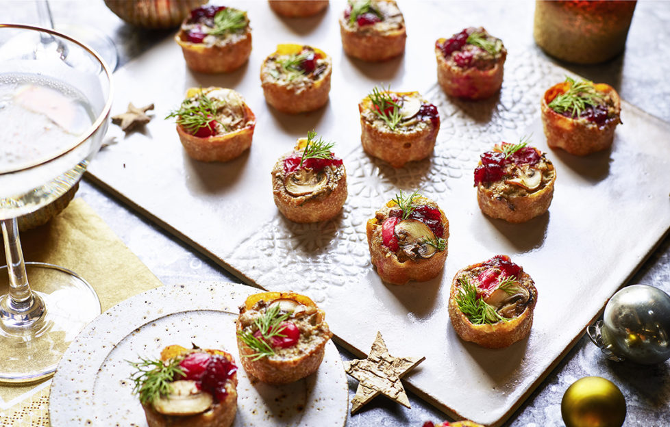 Christmas canapes on a board with dill sprigs and mushrooms