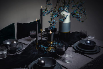 Dark themed Christmas tablescaping with black candles and blue faux berries