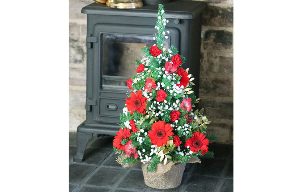 mini floral tree christmas tree on hearth by stove