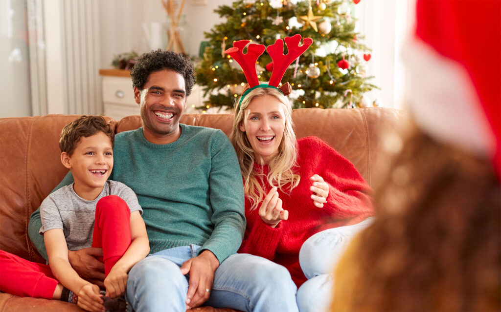 parents and 2 children play charades at christmas
