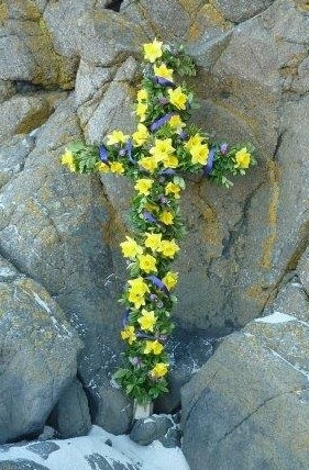 A cross adorned with daffodils for the outdoor event.