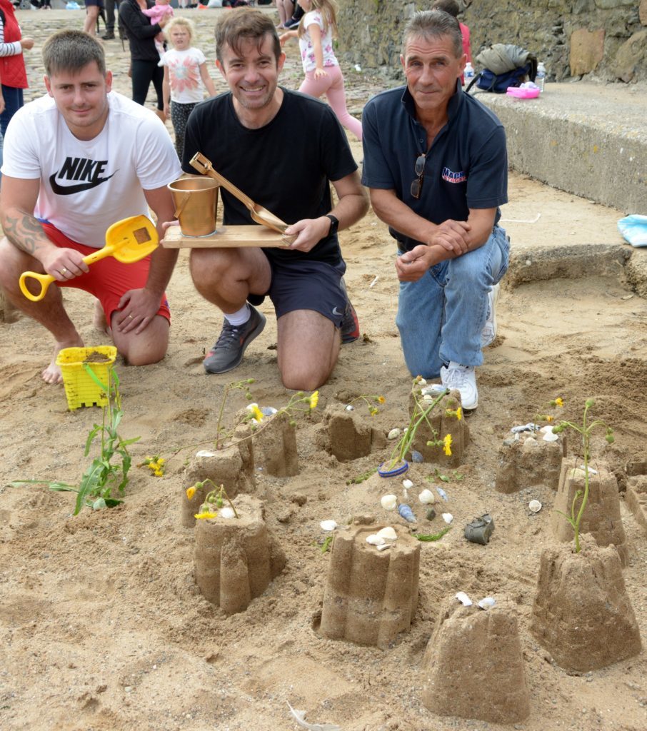 ​By the time judging was finished Finlay Blair had left the beach and from left: his dad Rhys Blair collected the prize from Jamie McIvor and Jamie McLean. 25_c32sandcastles02_RhysBlair_JamieMcIvor_JamieMcLean
