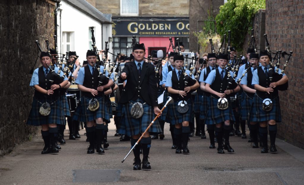 Scottish and European champion drum major Liam Renton leads pipers and drummers 'up the close' to Springbank Distillery.