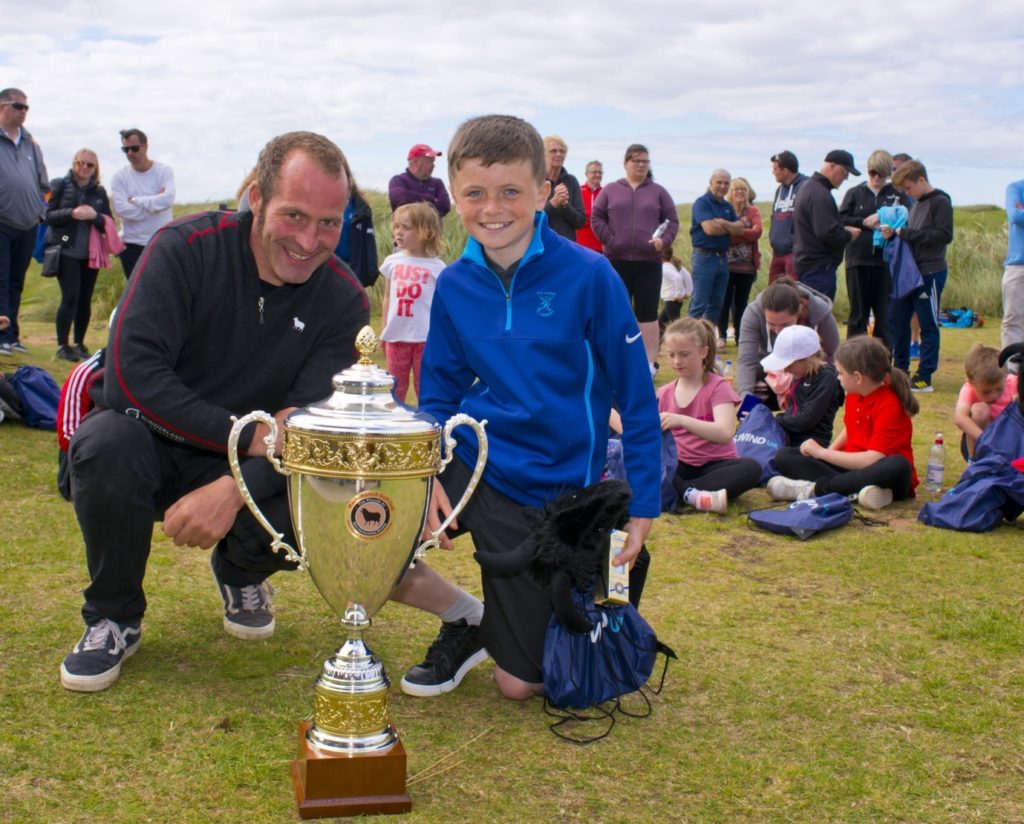 All the juniors who competed in the skills challenge were winners and received commemorative medals and goodie bags made up by the club's friends at CS Wind. Overall champions in four age divisions were awarded extra prizes. Jake MacMillan, pictured here with greenkeeper Simon Freeman, was the winner of the 10 to 12-year-old section. Photo: John McFadyen.