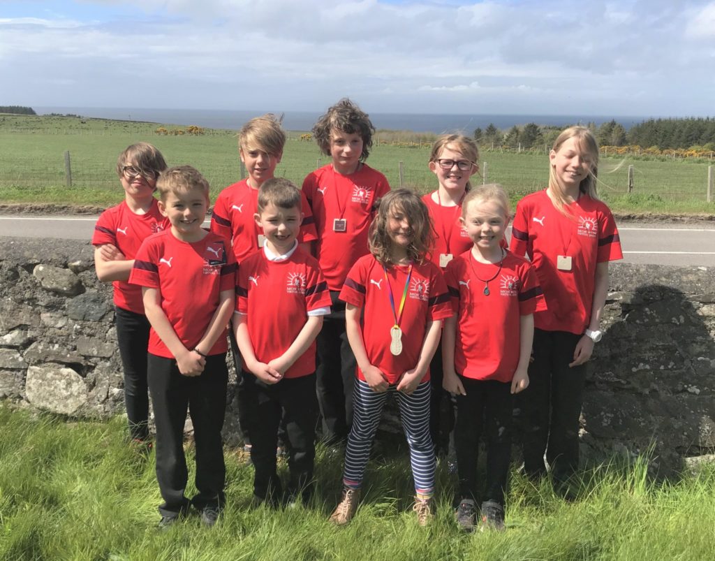 Pupils at Glenbarr Primary School, who have taken on the challenge of completing their virtual MOKRUN together, modelling the T-shirt and medal which junior participants will receive.