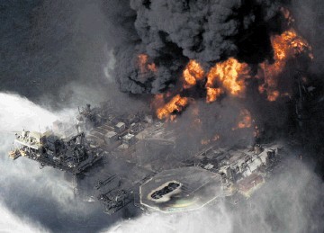 DISASTER: The   Deepwater Horizon  rig ablaze  with, inset, a bird covered with oil from the spill