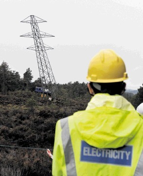 DOWN SHE GOES: A pylon is toppled before being cut up near Nethybridge. David Whittaker-Smith