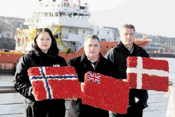 LAYING WREATHS FOR NATIONAL FLAGS: From left, Hege-Merethe Bengtsson, of the Norwegian Union of Marine Engineers, Steve Todd and ITF inspector Tore Steine, at Footdee, Aberdeen. Kevin Emslie