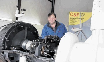 GENERATING INTEREST: John Flaherty with a  20 kilowatt wind turbine  at his  firm's new base at  Turriff. Joe Watson