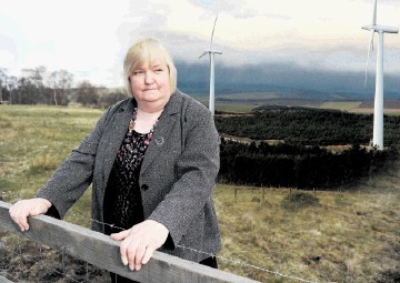 CONCERNS:  Vivian Roden, of Strathdearn Community Council, with a windfarm development inset in background