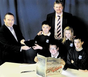 TEAMWORK: Northfield Academy pupils, from left, William Urquhart, 12, Jake Tahin, 12, Lauryn Shearer, 12, and Callum Hopkin, 13, receive an iPad from Shell's communications advisor David Rodger, left. Head teacher Neil Hendry is on right